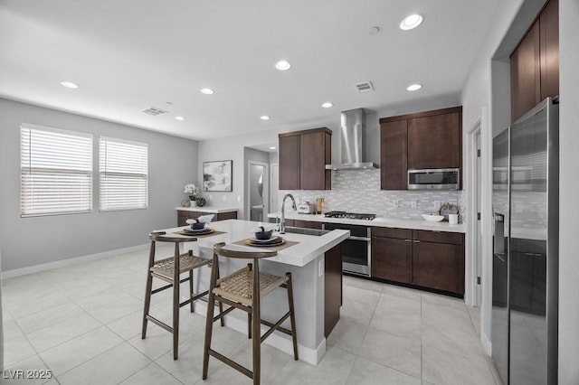 635 Pyrite Will St, Las Vegas, NV 89138 - kitchen featuring wall chimney exhaust hood, appliances with stainless steel finishes, light countertops, dark brown cabinetry, and recessed lighting