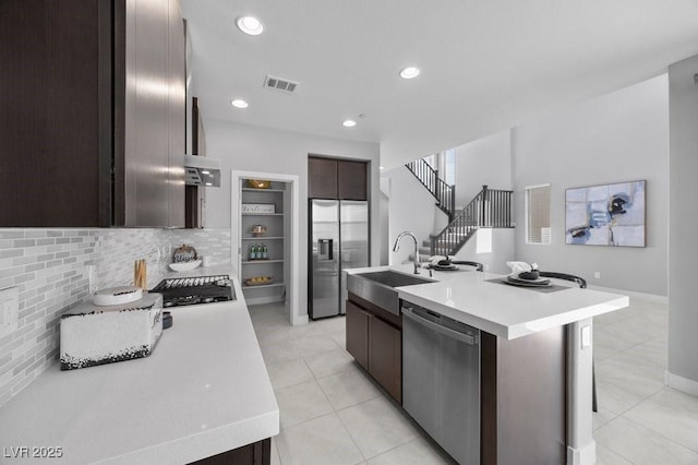 635 Pyrite Will St, Las Vegas, NV 89138 - kitchen featuring appliances with stainless steel finishes, light countertops, dark brown cabinetry, decorative backsplash, and recessed lighting