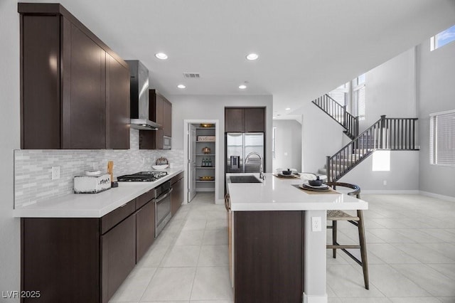 635 Pyrite Will St, Las Vegas, NV 89138 - kitchen featuring wall chimney exhaust hood, a kitchen bar, light tile patterned floors, dark brown cabinetry, and recessed lighting