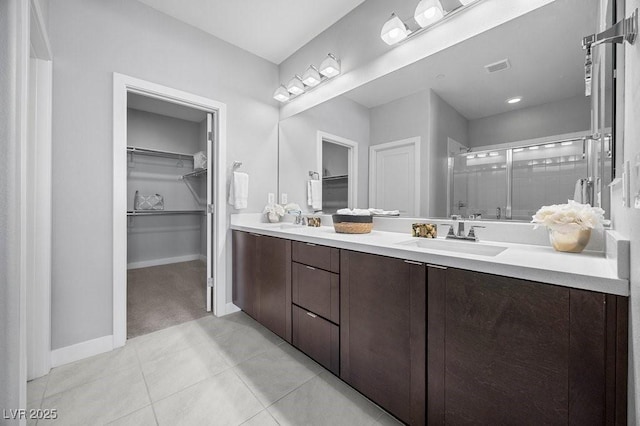 635 Pyrite Will St, Las Vegas, NV 89138 - bathroom featuring a spacious closet, a shower stall, double vanity, and tile patterned floors