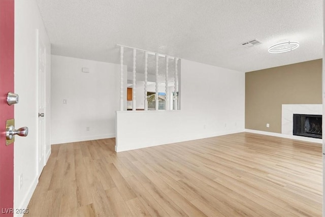 3908 Longfellow St, Las Vegas, NV 89115 - unfurnished living room with light wood-style floors, a textured ceiling, and a tile fireplace