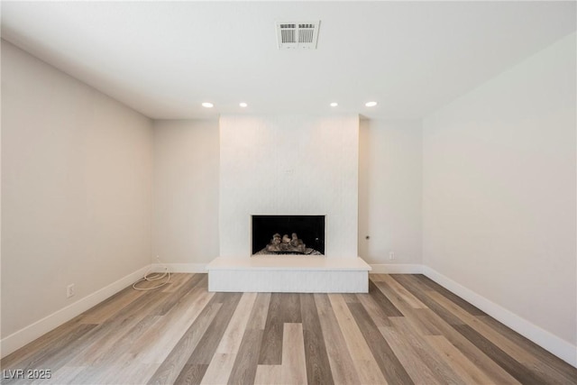 1712 E Oakey Blvd, Las Vegas, NV 89104 - unfurnished living room with recessed lighting, light wood-style floors, and a fireplace