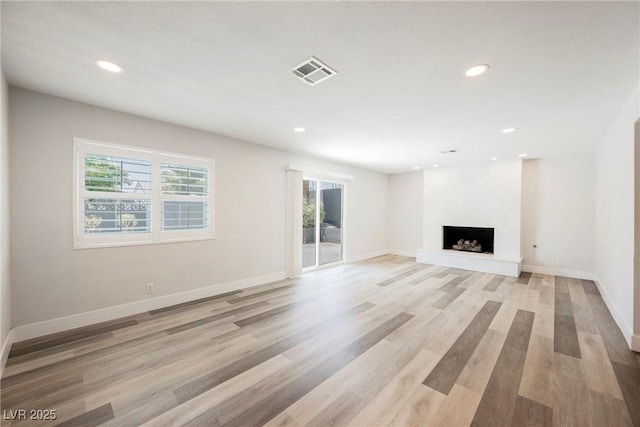 1712 E Oakey Blvd, Las Vegas, NV 89104 - unfurnished living room with light wood finished floors, recessed lighting, and a fireplace with raised hearth