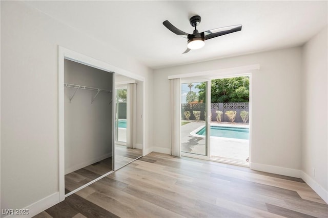 1712 E Oakey Blvd, Las Vegas, NV 89104 - unfurnished bedroom featuring access to outside, wood finished floors, a closet, and a ceiling fan