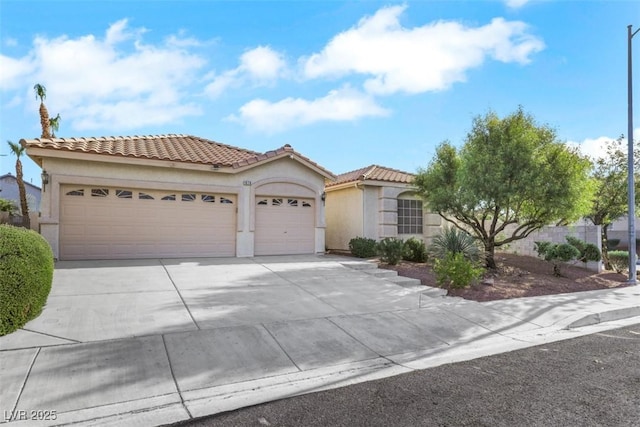1078 Broomfield Dr, Henderson, NV 89074 - mediterranean / spanish house with stucco siding, concrete driveway, an attached garage, and a tiled roof