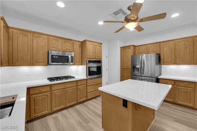 2167 Fairweather St, Henderson, NV 89052 - kitchen featuring appliances with stainless steel finishes, light wood finished floors, a ceiling fan, light countertops, and ornamental molding