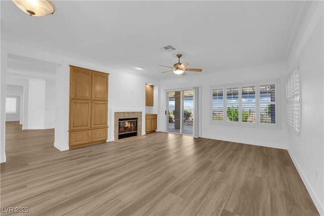 2167 Fairweather St, Henderson, NV 89052 - unfurnished living room featuring ceiling fan, light wood-style floors, crown molding, and a fireplace with flush hearth
