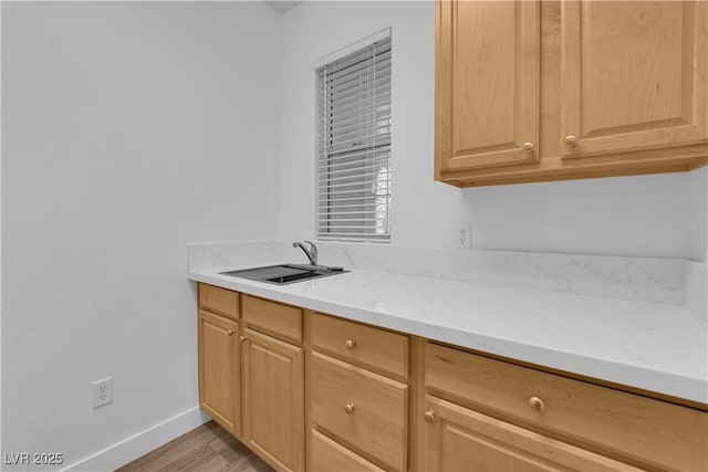 2167 Fairweather St, Henderson, NV 89052 - kitchen featuring light wood-type flooring, light brown cabinets, and light stone counters