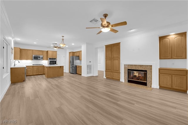 2167 Fairweather St, Henderson, NV 89052 - unfurnished living room featuring ceiling fan, light wood-type flooring, recessed lighting, crown molding, and a fireplace