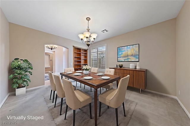9208 Brilliant Ore Dr, Las Vegas, NV 89143 - dining area with a chandelier, arched walkways, light colored carpet, and built in shelves