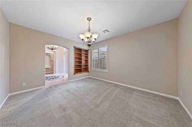 9208 Brilliant Ore Dr, Las Vegas, NV 89143 - carpeted spare room featuring a chandelier, built in features, and arched walkways