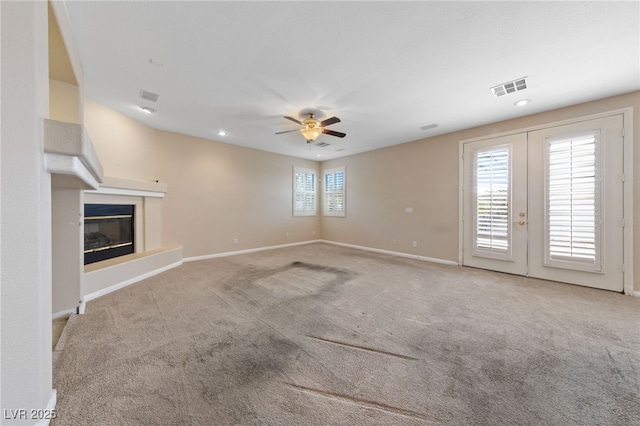 9208 Brilliant Ore Dr, Las Vegas, NV 89143 - unfurnished living room featuring carpet, french doors, a ceiling fan, a glass covered fireplace, and recessed lighting