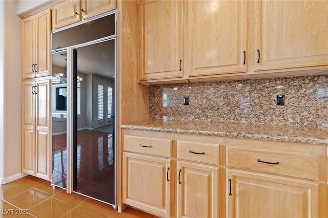 9208 Brilliant Ore Dr, Las Vegas, NV 89143 - kitchen featuring light brown cabinets, backsplash, light stone counters, and light tile patterned flooring