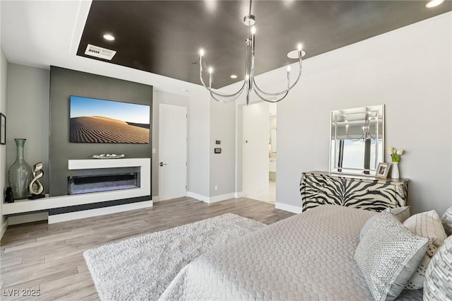 426 Tranquil Peak Ct, Henderson, NV 89012 - bedroom featuring a glass covered fireplace, wood finished floors, recessed lighting, and connected bathroom