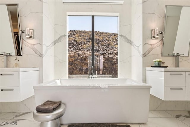 426 Tranquil Peak Ct, Henderson, NV 89012 - full bathroom with marble tiled flooring, a freestanding bath, vanity, and stone wall