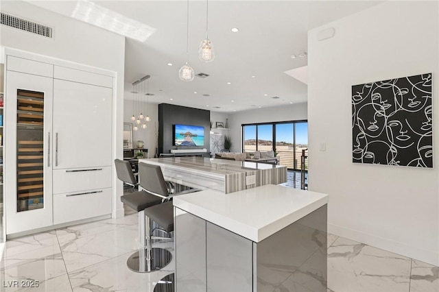 426 Tranquil Peak Ct, Henderson, NV 89012 - kitchen with modern cabinets, light marble finish floors, a spacious island, white cabinetry, and recessed lighting