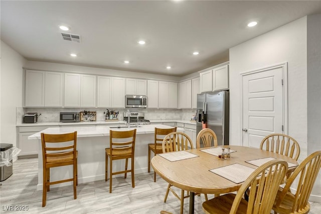 2807 Lindsey Springs St, Las Vegas, NV 89142 - kitchen with stainless steel appliances, an island with sink, decorative backsplash, light countertops, and recessed lighting