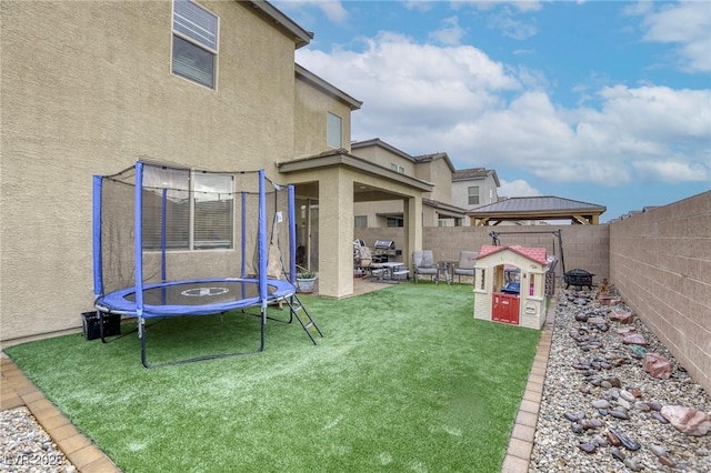 2807 Lindsey Springs St, Las Vegas, NV 89142 - fenced backyard with a trampoline, a gazebo, and a patio