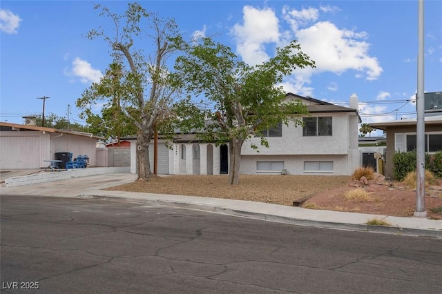 6340 Factor Ave, Las Vegas, NV 89107 - tri-level home with concrete driveway, a garage, and stucco siding