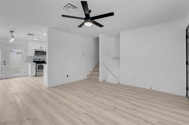 6340 Factor Ave, Las Vegas, NV 89107 - unfurnished living room featuring light wood-style floors, ceiling fan, stairs, and recessed lighting