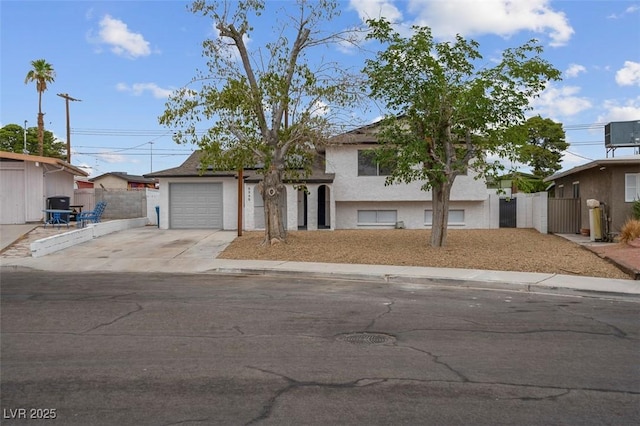 6340 Factor Ave, Las Vegas, NV 89107 - split level home featuring concrete driveway, an attached garage, a gate, and stucco siding