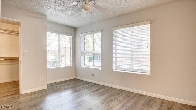 2200 S Fort Apache Rd Unit 1025, Las Vegas, NV 89117 - unfurnished bedroom featuring a textured ceiling, wood finished floors, a spacious closet, a closet, and ceiling fan
