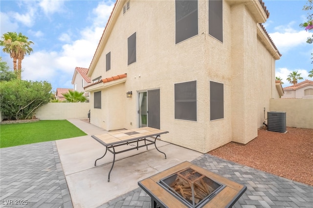 77 Huntfield Dr, Henderson, NV 89074 - back of house with stucco siding, a fenced backyard, an outdoor fire pit, and a patio area