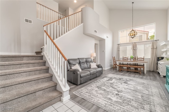 77 Huntfield Dr, Henderson, NV 89074 - living area featuring a chandelier, a towering ceiling, stairway, and wood finished floors