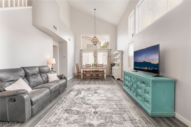 77 Huntfield Dr, Henderson, NV 89074 - living room featuring a chandelier, wood finished floors, and high vaulted ceiling