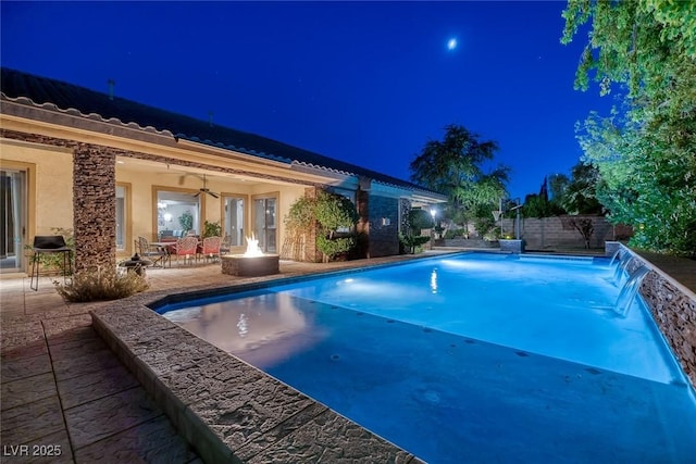 3668 Hillary Elan Ct, Las Vegas, NV 89139 - pool at night featuring ceiling fan, a patio, and a fenced backyard