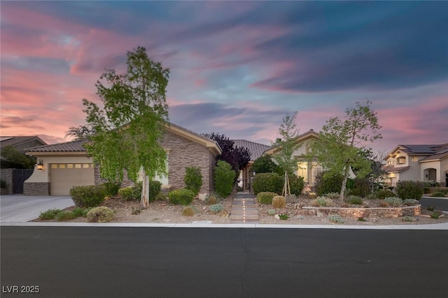 3668 Hillary Elan Ct, Las Vegas, NV 89139 - view of front facade featuring a garage, concrete driveway, stone siding, and stucco siding