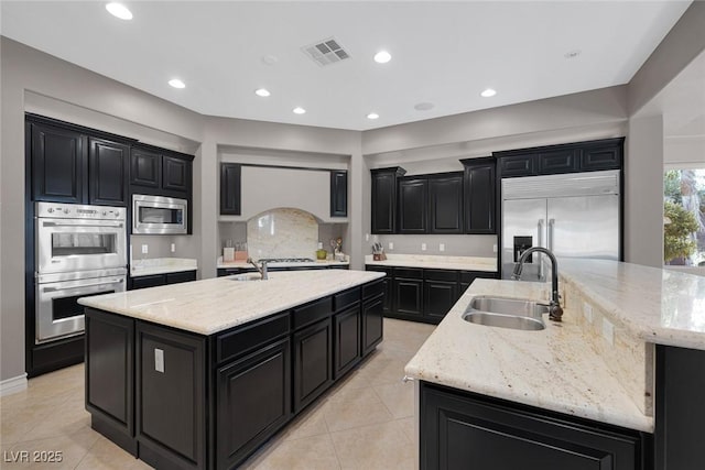 3668 Hillary Elan Ct, Las Vegas, NV 89139 - kitchen featuring a large island, built in appliances, dark cabinetry, light tile patterned floors, and recessed lighting