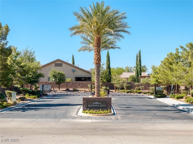 3668 Hillary Elan Ct, Las Vegas, NV 89139 - view of property hidden behind natural elements with stucco siding, uncovered parking, and a gate