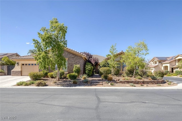 3668 Hillary Elan Ct, Las Vegas, NV 89139 - view of property hidden behind natural elements featuring a tile roof, an attached garage, stone siding, and driveway