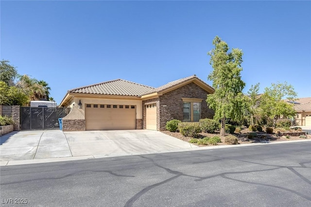 3668 Hillary Elan Ct, Las Vegas, NV 89139 - view of front of property featuring stone siding, a garage, a tiled roof, stucco siding, and driveway