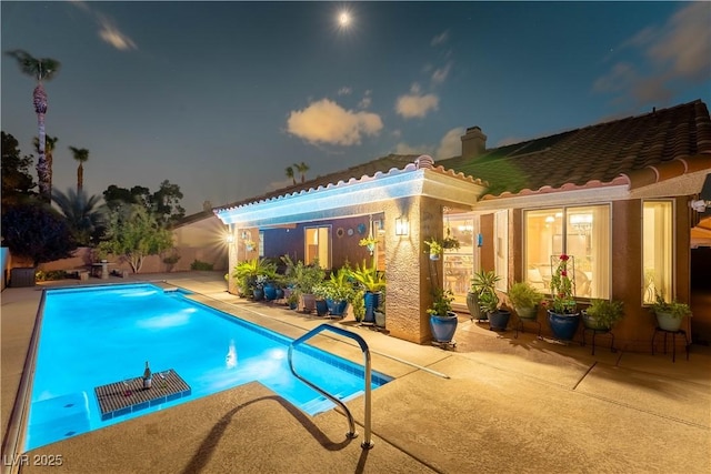 5620 Silver Belle St, Las Vegas, NV 89149 - pool at night featuring a patio area and an outdoor pool