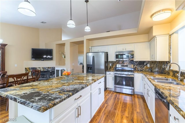 5620 Silver Belle St, Las Vegas, NV 89149 - kitchen with appliances with stainless steel finishes, wood finished floors, dark stone counters, white cabinetry, and tasteful backsplash