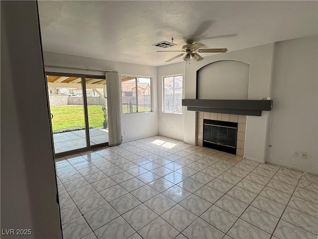 6492 Silent Pine Ave, Las Vegas, NV 89156 - unfurnished living room with a ceiling fan, light tile patterned floors, a fireplace, and a textured ceiling