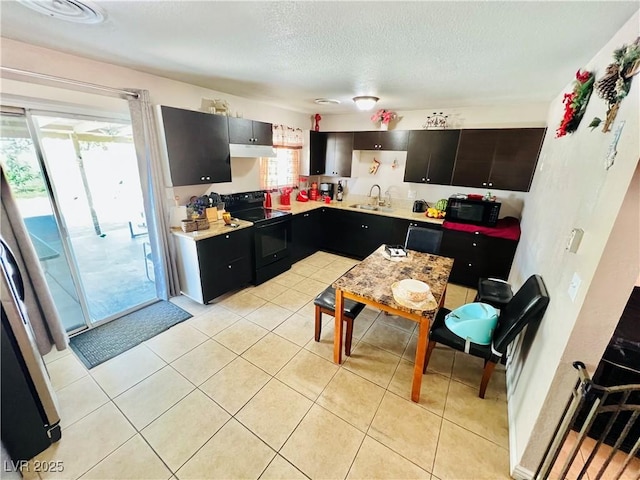 4109 Studio St, Las Vegas, NV 89115 - kitchen featuring black appliances, light countertops, light tile patterned floors, a textured ceiling, and under cabinet range hood
