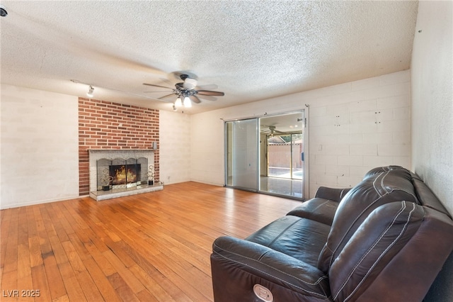 4436 E Ogden Ave, Las Vegas, NV 89110 - living room with ceiling fan, a textured ceiling, wood-type flooring, and a fireplace