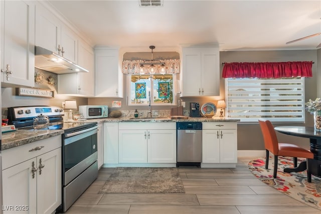 908 Bonita Ave, Las Vegas, NV 89104 - kitchen with appliances with stainless steel finishes, under cabinet range hood, white cabinetry, and light stone counters