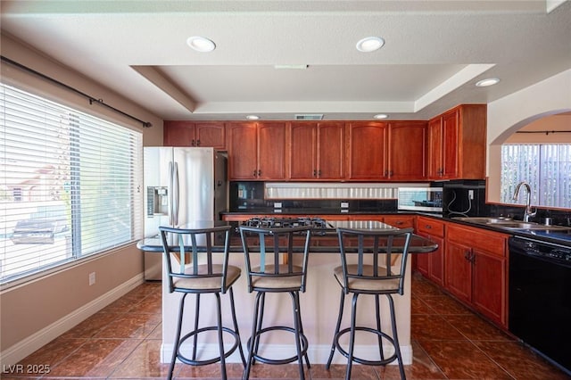 8708 Western Saddle Ave, Las Vegas, NV 89129 - kitchen with appliances with stainless steel finishes, a raised ceiling, dark countertops, plenty of natural light, and recessed lighting