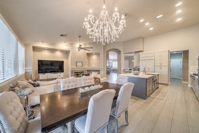 1131 Magic Meadow St, Henderson, NV 89052 - dining area featuring arched walkways, ceiling fan, recessed lighting, a fireplace, and a chandelier