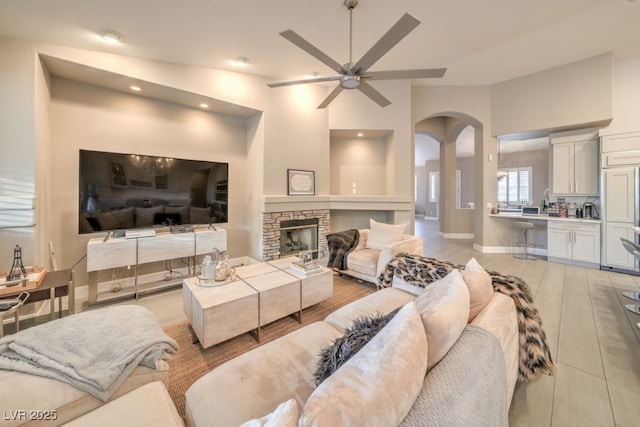 1131 Magic Meadow St, Henderson, NV 89052 - living room featuring a ceiling fan, arched walkways, a stone fireplace, recessed lighting, and vaulted ceiling