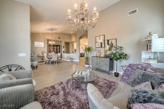 1131 Magic Meadow St, Henderson, NV 89052 - living room featuring a chandelier, wood finished floors, arched walkways, and lofted ceiling