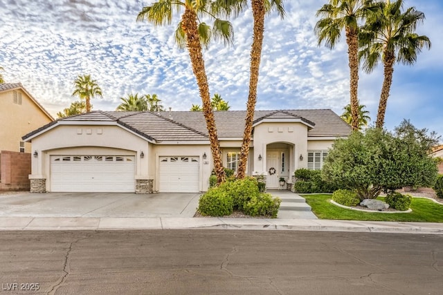 1131 Magic Meadow St, Henderson, NV 89052 - view of front of property featuring an attached garage, stucco siding, driveway, and stone siding