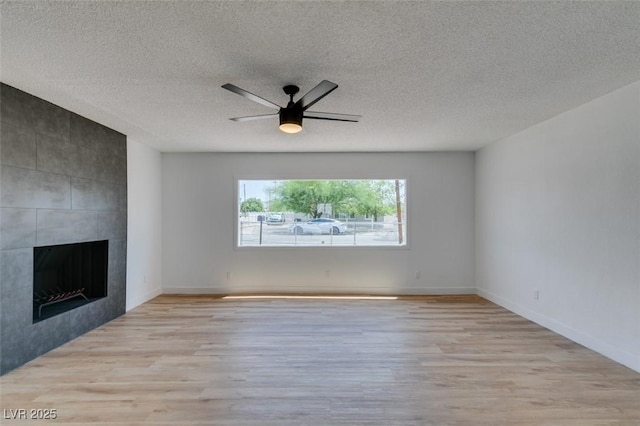 148 Fir St, Henderson, NV 89015 - unfurnished living room featuring wood finished floors, a fireplace, a textured ceiling, and ceiling fan