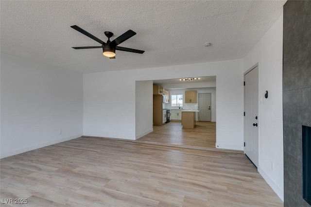 148 Fir St, Henderson, NV 89015 - unfurnished living room featuring light wood finished floors, a ceiling fan, a fireplace, and a textured ceiling