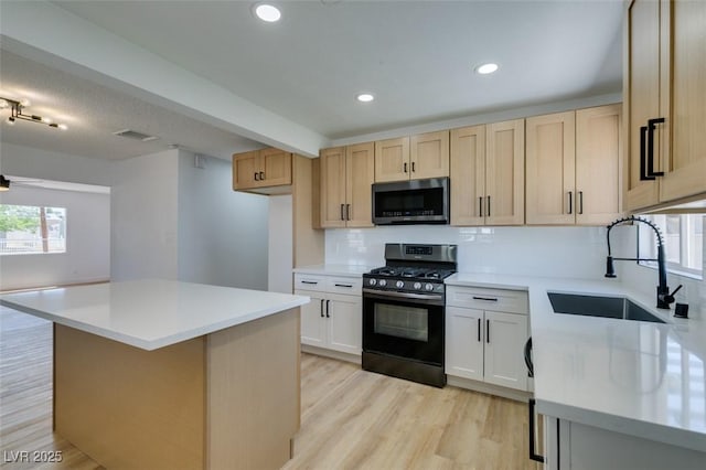 148 Fir St, Henderson, NV 89015 - kitchen with stainless steel microwave, range with gas stovetop, backsplash, light brown cabinets, and light countertops