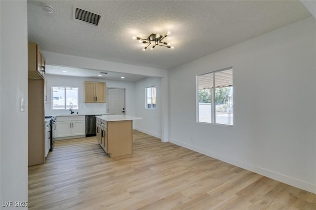 148 Fir St, Henderson, NV 89015 - kitchen featuring dishwashing machine, a kitchen island, light wood-style floors, light countertops, and a textured ceiling